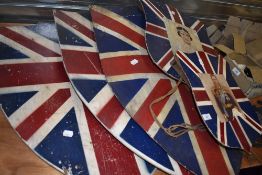 A collection of wooden shields painted with the union jack two of which have pictures of George