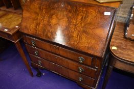 A reproduction bureau having flame mahogany frontage with three drawers