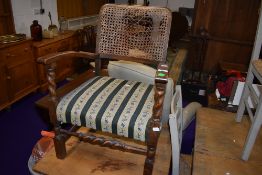 An early 20th Century oak low seat carver chair having bergere style canework back (af) and woolwork