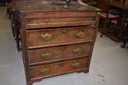 An 18th Century oak chest of three long drawers (plus miser's drawers to side) cushion style side