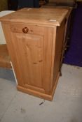 A modern yellow pine pull out laundry cupboard