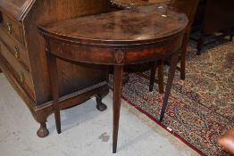A 19th Century mahogany demi lune fold over tea table having inlaid detailing on tapered legs