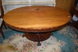An early 19th century possibly William IV dining table of oval form on tilt top having mahogany
