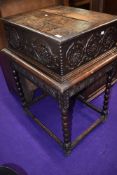 A Jacobean style marriage of side table and bible box having heavily carved frontage