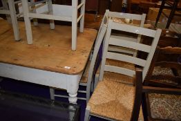 A vintage farm house style kitchen table and six chairs having straw seats and ladder backs