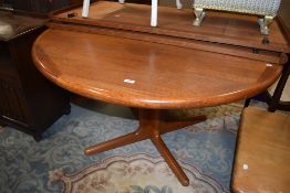 A mid century style extending circular dining table on tripod base