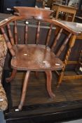 A stained frame spindle back arm chair on interesting swivel base