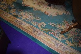 A large modern carpet square aprox 259x353cm in a floral design on green ground