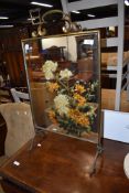 A late Victorian mirror back fire screen having hand decorated floral design