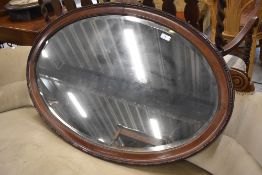 An early 20th Century mahogany frame oval wall mirror, width approx 100cm