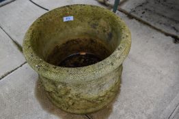 A stone effect cast garden planter with scenes of cherubs and fruit