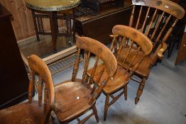 A set of four (three plus one) traditional golden oak kitchen/dining chairs having turned spindle