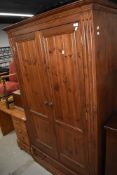 A red stained pine wardrobe on drawer base