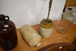 Two glass demi johns and similar earthen ware pots