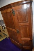 A Victorian oak hall robe, of canted form, in the Arts and Crafts style with cornice detailing,