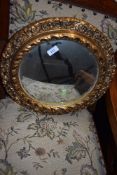 A circular bulls eye glassed mirror with plaster gilt frame
