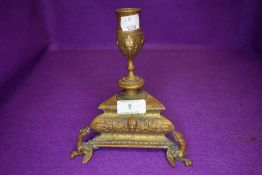 A bronze candle stick having a neo classical design with triangle design on dragon feet with green