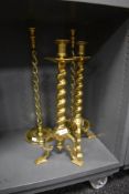 Two pairs of impressive brass candle sticks one set having three footed base and a similar barley