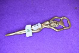 A brass bottle opener in the form of a nude woman