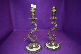 A pair of table lamps having cast metal scroll decoration