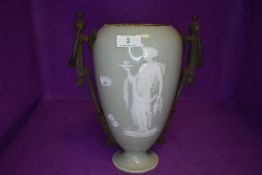 An antique mantle urn or vase having a Jasperware design over green porcelain ground with twin