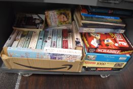 A selection of paper back coffee table books and selection of jigsaws