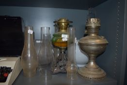 Two oil burning lamps one having cast metal base with green glass well