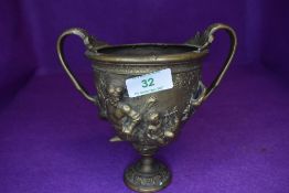 A bronze cast twin handle urn or trophy cup decorated with mythological centaur copied from