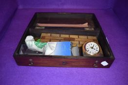 A mahogany case having brass carry handle with some contents