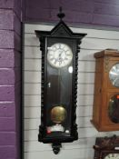 An enamel faced wall clock having single weight pendulum