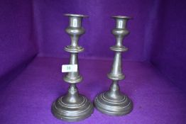 A pair of antique pewter candle sticks having telescopic push