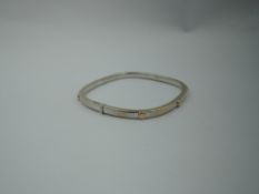 An Italian 18ct white and yellow gold hinged bangle having screw head style decoration, approx 11.