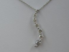 A seven stone graduated diamond pendant, total approx 0.32ct, in an 18ct white gold mount stamped