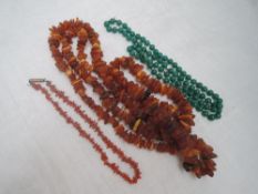 A long string of rough cut Baltic amber, string of branch coral and knotted string of green '