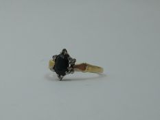 An oval sapphire and diamond chip star cluster to shaped moulded shoulders on a yellow metal loop,