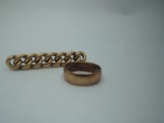 A yellow metal brooch stamped 10CT in the form of a piece of chain and a 9ct rose gold wedding band,