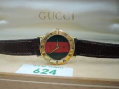 A lady's 1980's Gucci quartz wrist watch having stripe face and Roman numeral bezel dial to gold