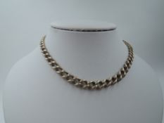 A yellow metal graduated curb link watch chain stamped 9ct having a dog leash clasp and rolled