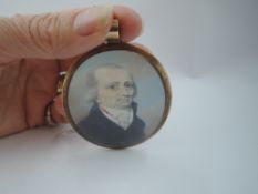 A portrait miniature of a Georgian gentleman having powdered hair, ruff collar and navy coat under