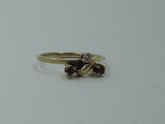 A diamond and ruby trio dress ring in a stylised mount on an 18ct gold loop, size N & approx 2.5g