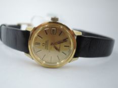 A lady's Omega Geneve automatic wrist watch having baton numeral dial and date aperture to champagne