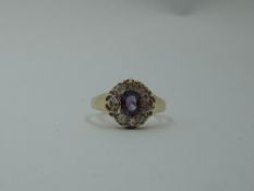A Victorian amethyst and diamond cluster dress ring having an oval central surrounded by old cut