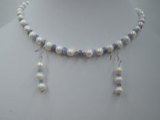 A string of cultured pearls with rough cut tanzanite spacers and matching drop earrings all having