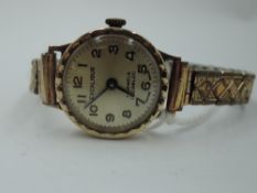 A 9ct gold wrist watch by Excalibur having Arabic numeral dial to champagne face on a gold plated