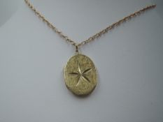 A 9ct gold oval locket having brushed finish with cut star decoration to front, on a 9ct gold