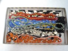 A selection of vintage and later strings of beads including mother of pearl, coral, amber style,