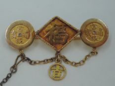 A Far Eastern yellow metal brooch stamped 18 having three panels bearing lettering, makers mark WN