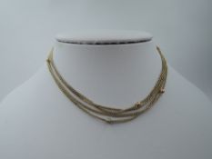A yellow metal chain with clasp bearing stamp 10C having 10 small ball interlinks, ( 1 missing)