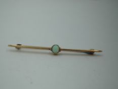 A yellow metal bar brooch stamped 15ct having a central opal stone, approx 3.3g