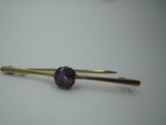 A yellow metal bar brooch stamped 9ct having central facetted amethyst, approx 3.9g